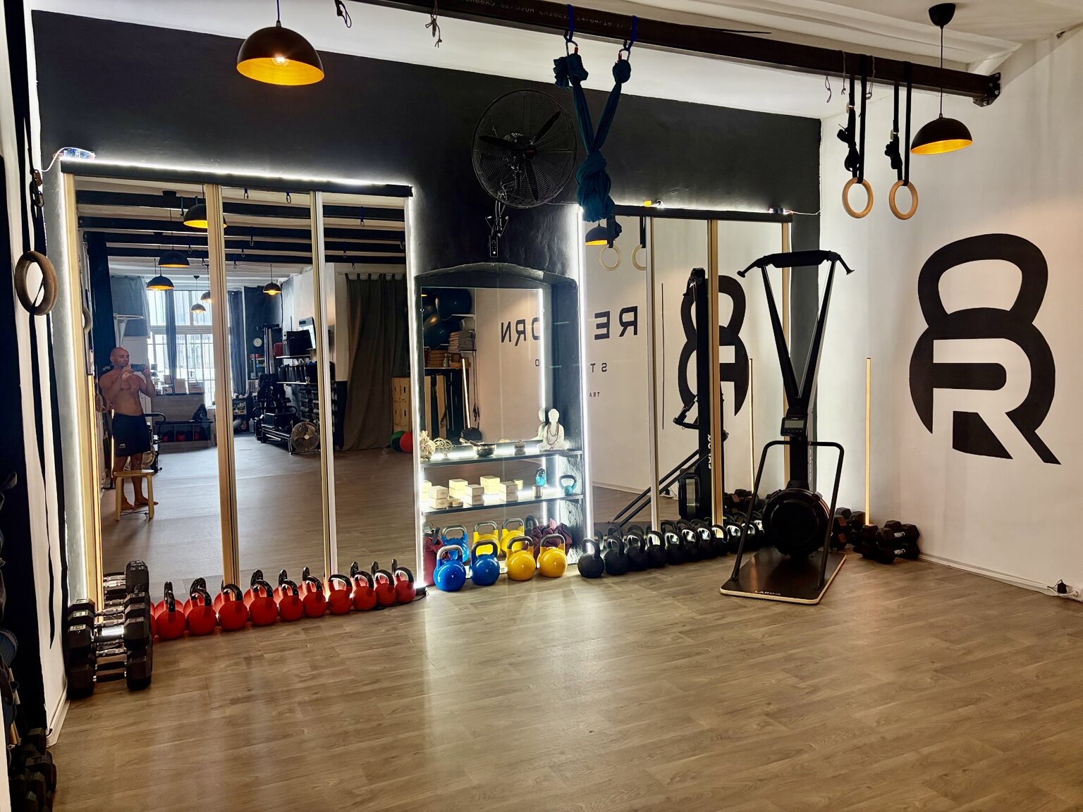 Kettlebells, SkiErg, anneaux et sangles dans l’espace d’entraînement de REBORN STUDIO